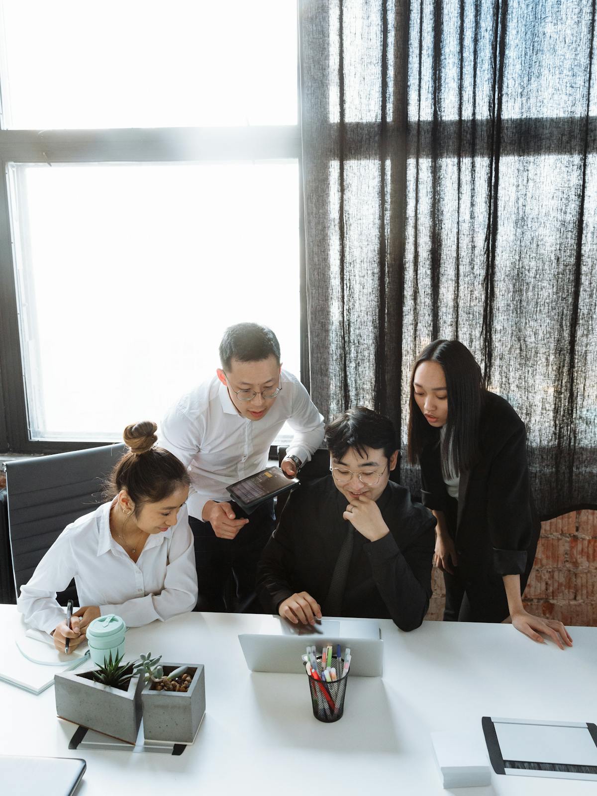 Екип в професионална офис среда, обсъждащ работен материал